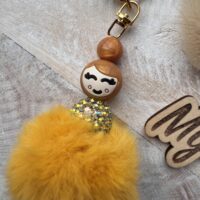 Gelukspopje parelmoer goud met pompon